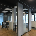 Bürofläche mit klarer Zonierung durch Glaswände und Akustikelemente von b connect